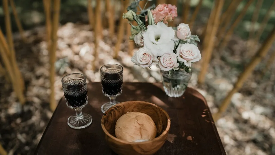 Two glasses of red wine and bread on a rustic wooden table