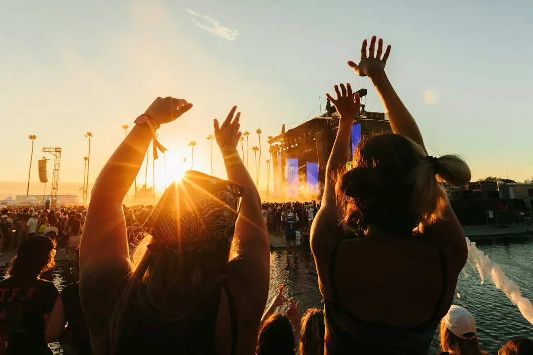 Crowd enjoying music festival at sunset